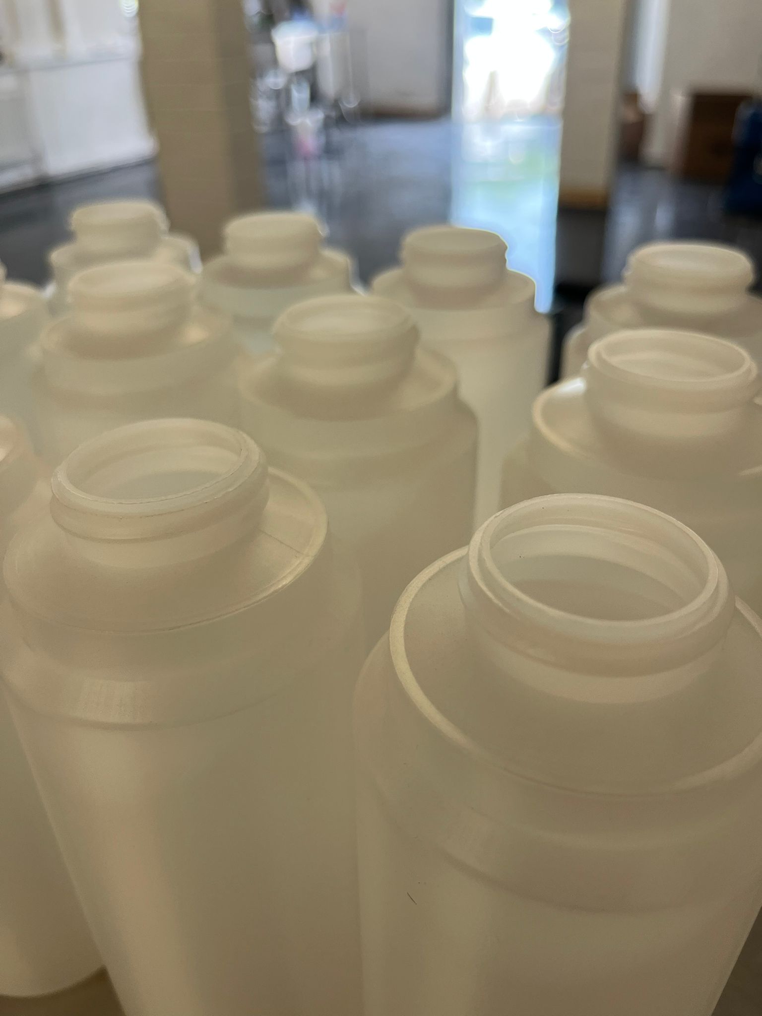 Empty food-grade bottles staged before a consumables filling run.