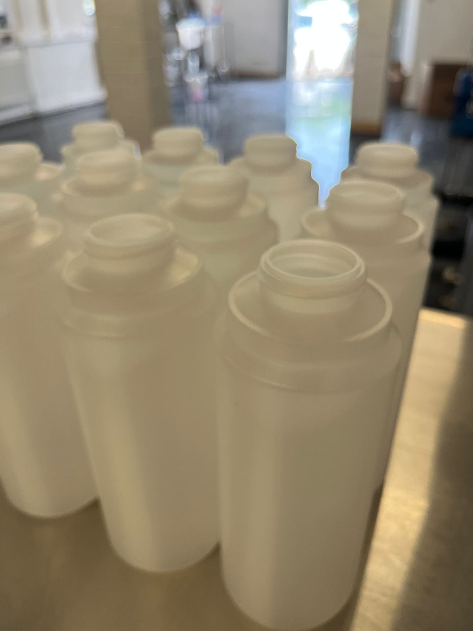 Empty bottles staged on stainless bench for Weight-Verified Filling Runs.