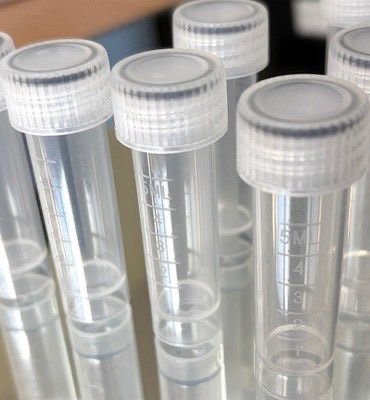 Graduated plastic vials with white caps - Small-format pharmaceutical and wellness packaging.