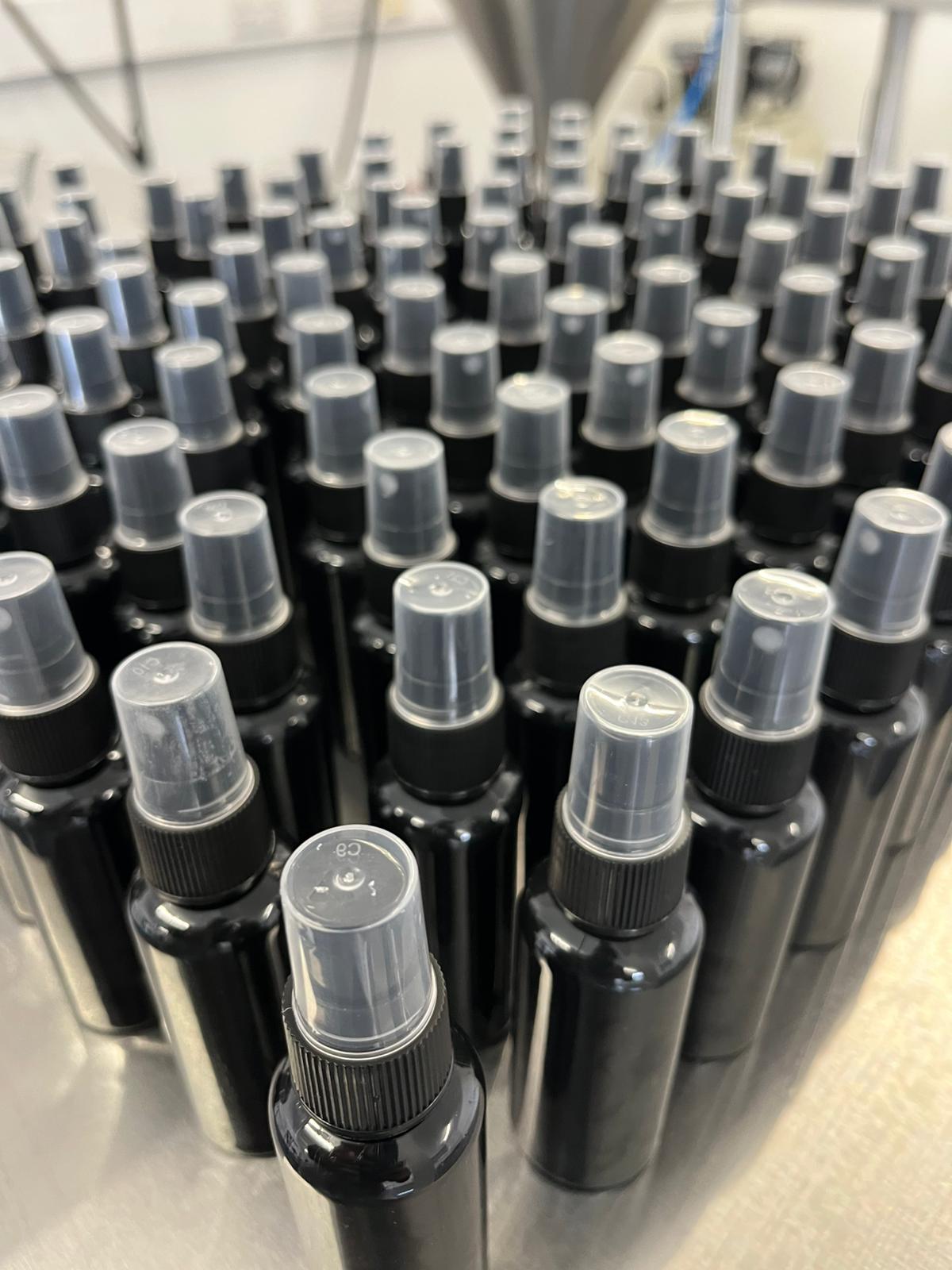 Uniform capped spray bottles in a production batch - Each unit coded and logged before release.